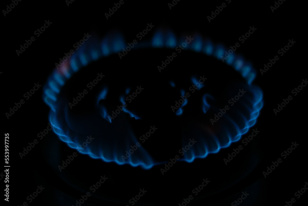Natural gas burning a blue flames on black background.