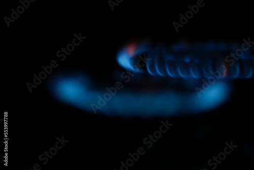 Natural gas burning a blue flames on black background.