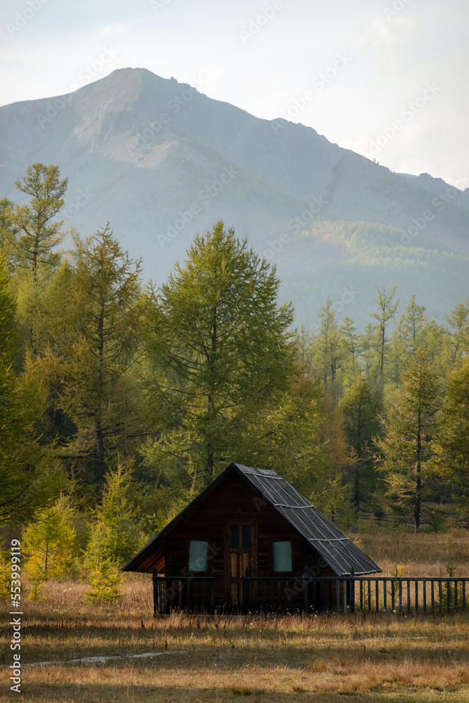 Cute small village houses on a foothill on a sunny day. Rural nomadic living, beautiful mountain in the background, golden hour.