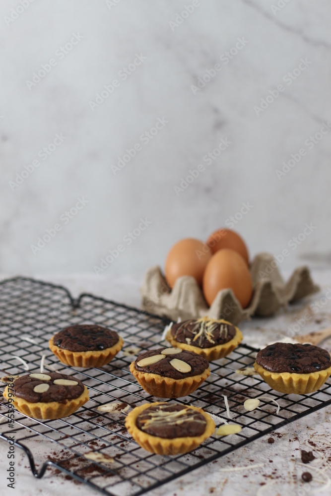 Small chocolate pie with almonds topping served on a cake rack, tastes sweet and savory. Food concept photo. Small chocolate pie with almonds topping served on a cake rack, tastes sweet and savory. Food concept photo.