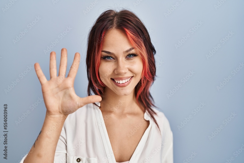 Young caucasian woman wearing casual white shirt over isolated background showing and pointing up with fingers number five while smiling confident and happy. Young caucasian woman wearing casual white shirt over isolated background showing and pointing up with fingers number five while smiling confident and happy.