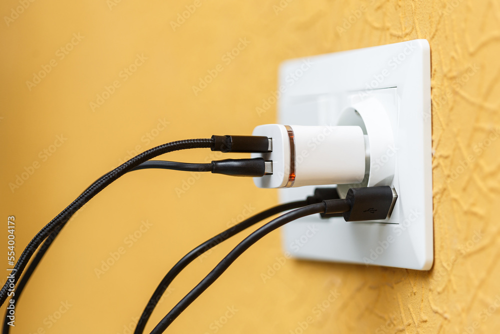White electric plug with built in usb ports and usb charger with multiple black and white cords. White electric plug with built in usb ports and usb charger with multiple black and white cords.
