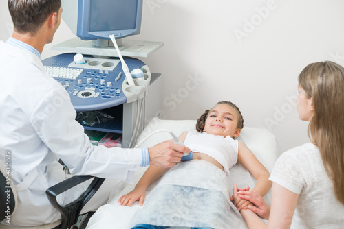 Doctor examines little patient abdomen at hospital