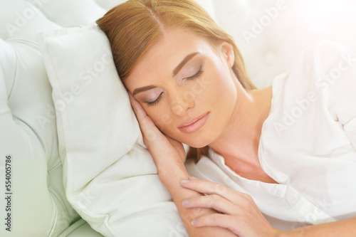 Beautiful young woman sleeping on soft bed 
