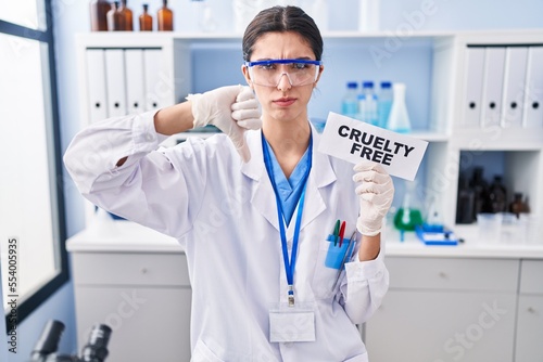 Young beautiful woman working on cruelty free laboratory with angry face  negative sign showing dislike with thumbs down  rejection concept