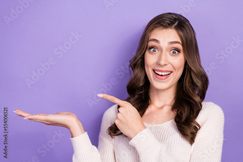 Photo of astonished lady arm direct empty space impressed low prices recommend offer feedback isolated on purple color background