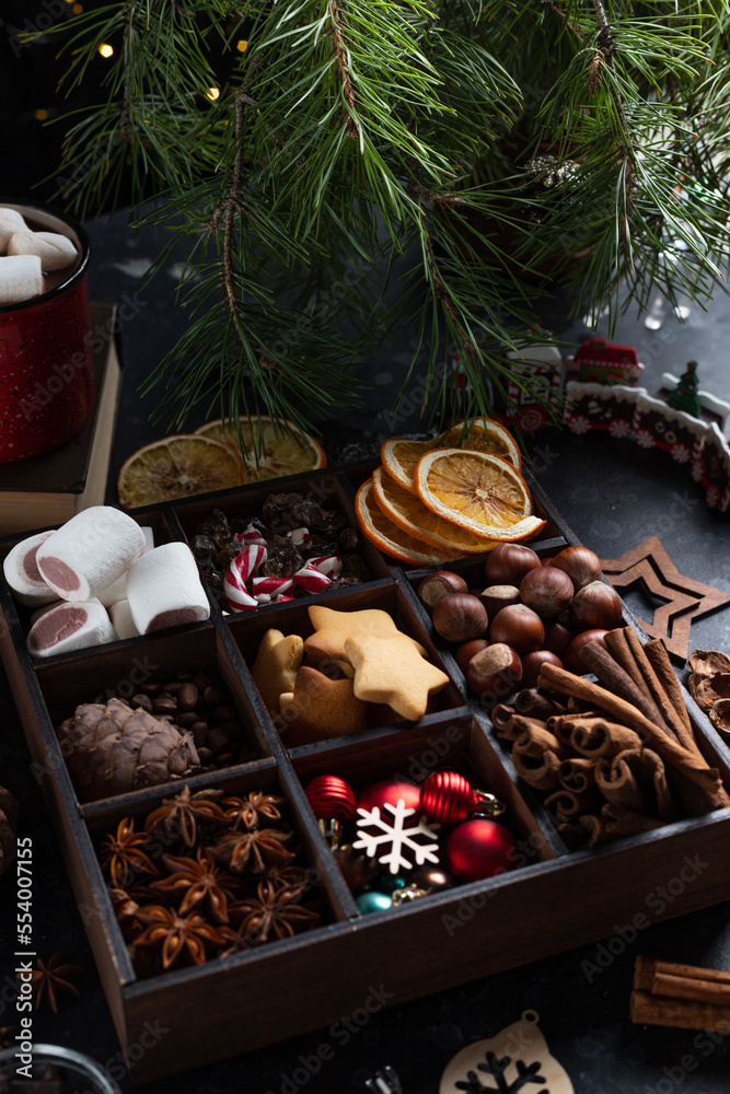 On the table there is a box with nine compartments in which nuts, cookies and spices are poured On the table there is a box with nine compartments in which nuts, cookies and spices are poured