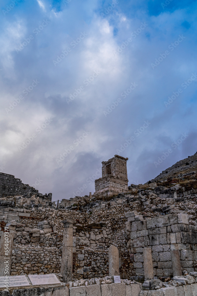View from ruins of Sagalassos ancient city with monuments buildings and fountain with cloudy blue sky 