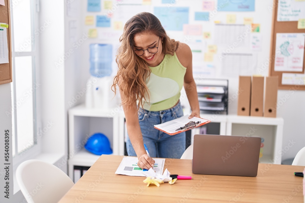 Young beautiful hispanic woman business worker reading documents at office Young beautiful hispanic woman business worker reading documents at office