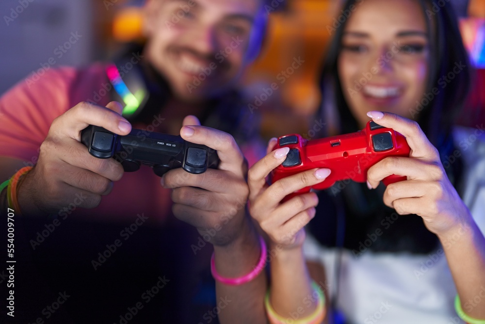 Man and woman streamers playing video game using computer and joystick at gaming room Man and woman streamers playing video game using computer and joystick at gaming room