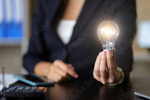 Businesswoman holding a light bulb, concept of idea.