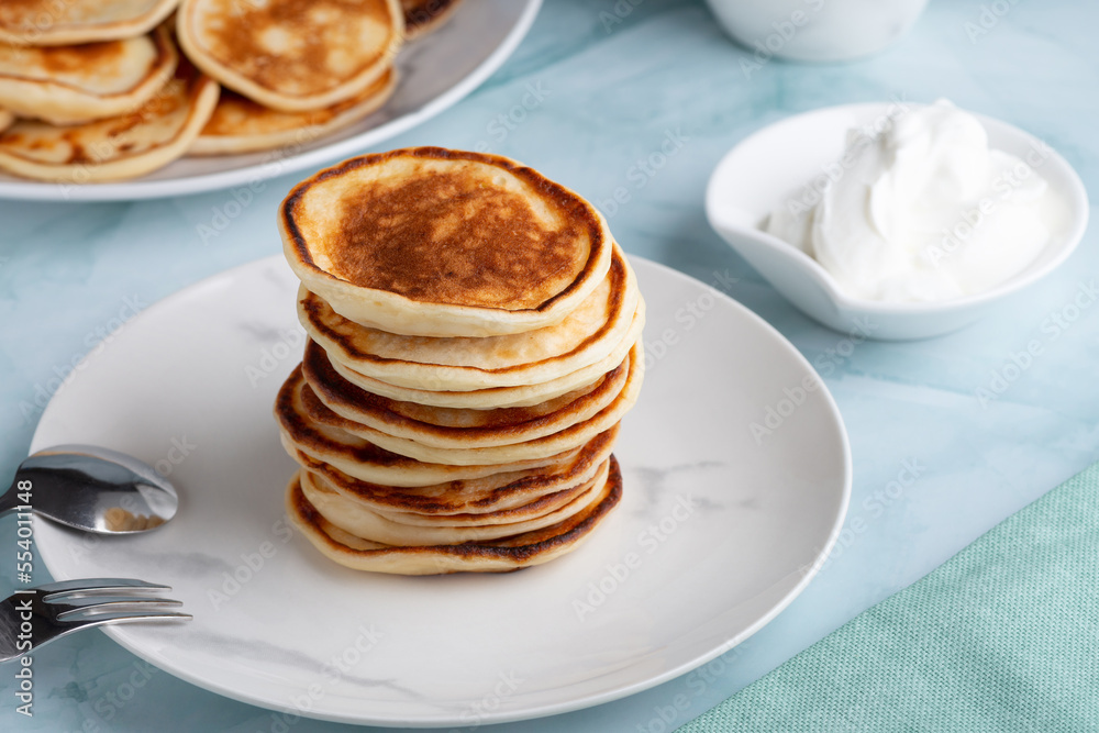 Pancakes with sour cream on the green table