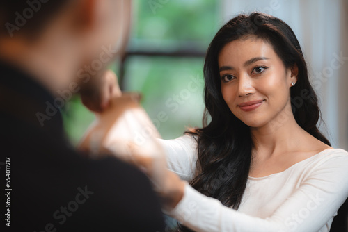 Bakery and coffee cafe business shop concept, Asian female wearing aprons, happily smiling to serving breakfast baked bread, beautiful woman staff service customer to delivery a food