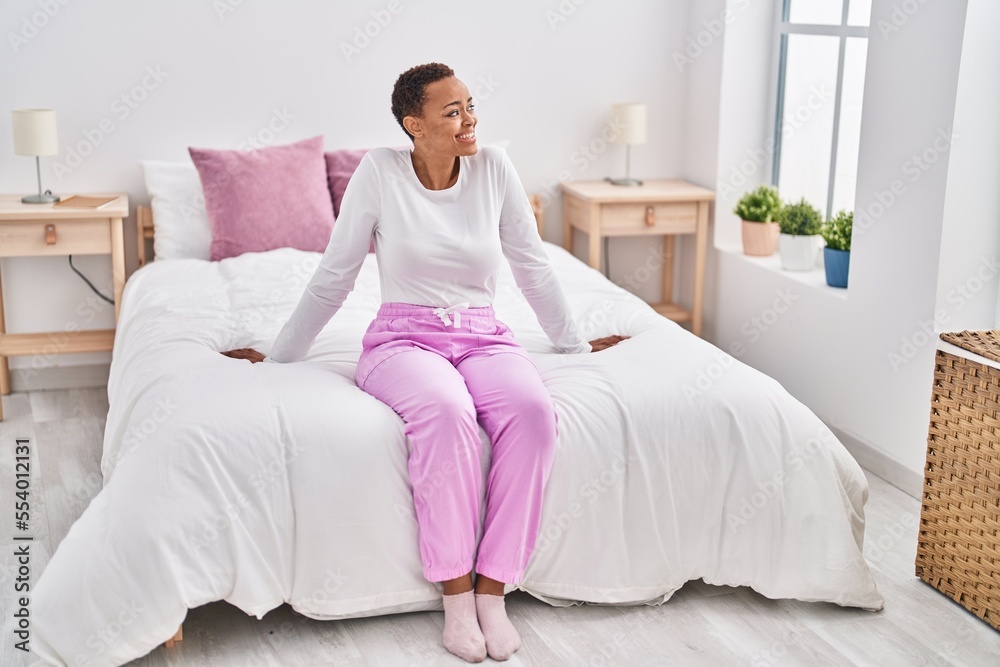 African american woman smiling confident sitting on bed at bedroom African american woman smiling confident sitting on bed at bedroom