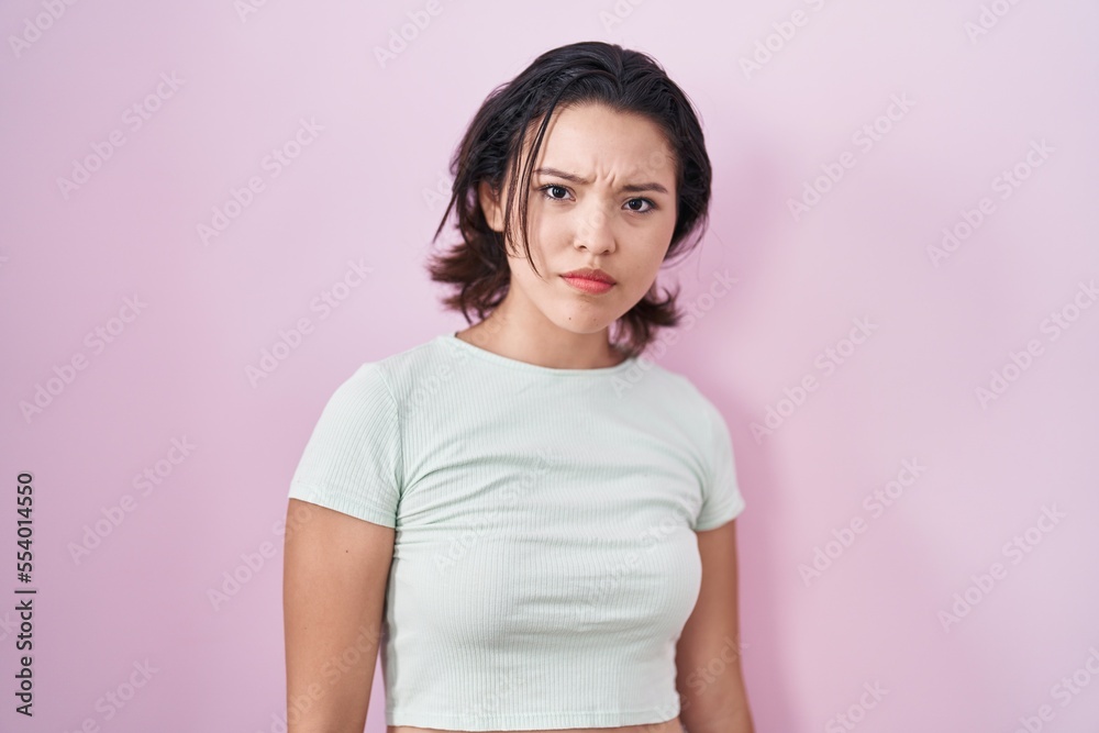 Hispanic young woman standing over pink background skeptic and nervous, frowning upset because of problem. negative person. Hispanic young woman standing over pink background skeptic and nervous, frowning upset because of problem. negative person.