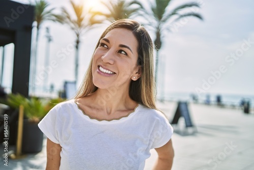 Young hispanic woman smiling confident at street