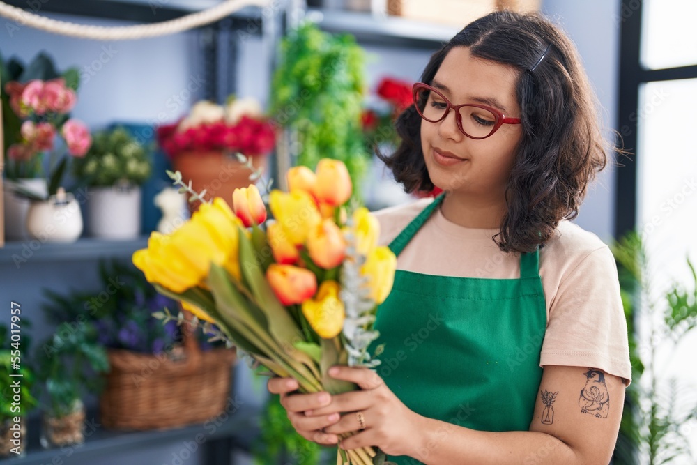 Young woman florist smiling confident prepare bouquet of flowers at florist