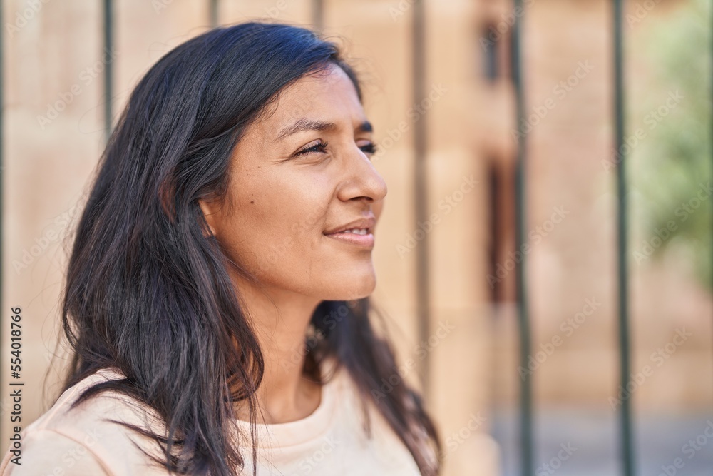 Young beautiful hispanic woman smiling confident looking to the side at street