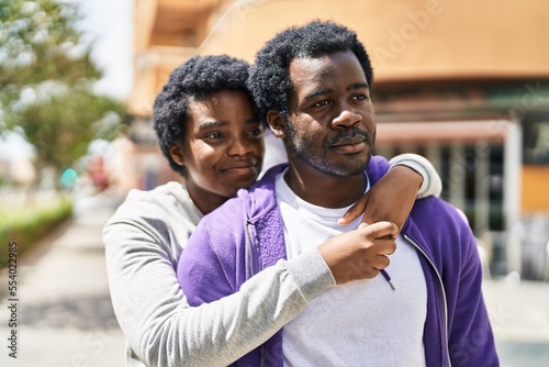 African american man and woman couple smiling confident hugging each other at street