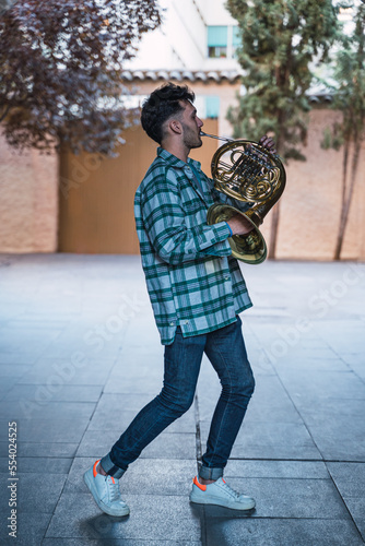 Obraz na płótnie Young man playing the horn in a tunes of zaragoza spain w salonie