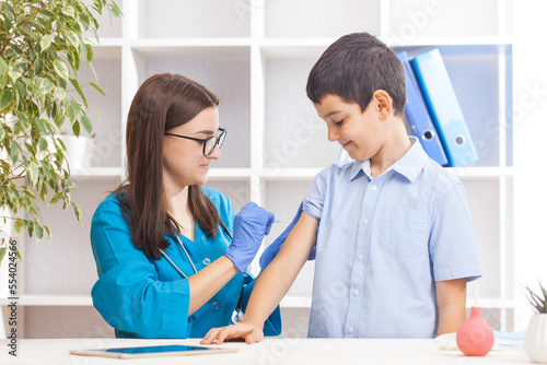vaccination of children, a little boy at a doctor's appointment, an injection in the arm photo