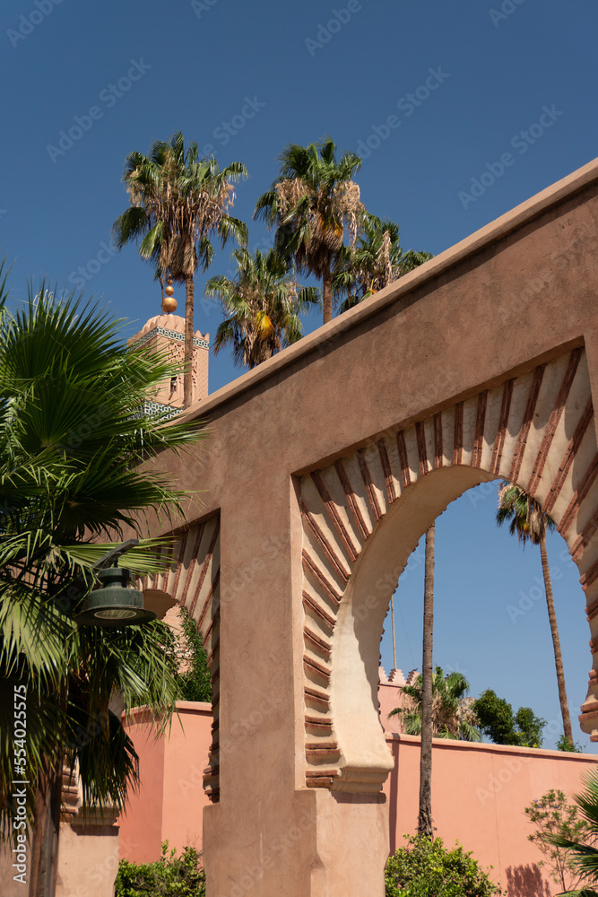 Arch building in a tropical city, Morocco, Marrakesh, Palms and tropical plants