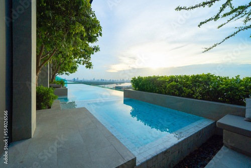 Swimming pool on rooftop of hotel apartment building in Bangkok downtown skyline, urban city view. Relaxing in summer season in travel holiday vacation concept. Recreation lifestyle. © tampatra