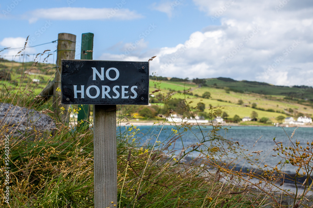 No Horses sign with sea and fields in the background No Horses sign with sea and fields in the background