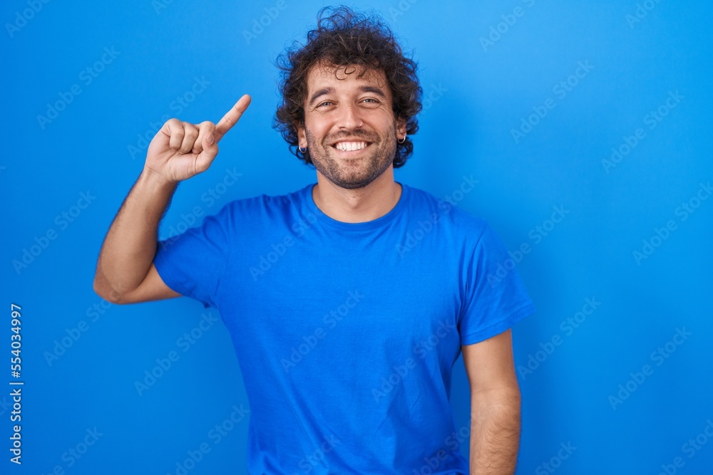 Hispanic young man standing over blue background smiling pointing to head with one finger, great idea or thought, good memory Hispanic young man standing over blue background smiling pointing to head with one finger, great idea or thought, good memory