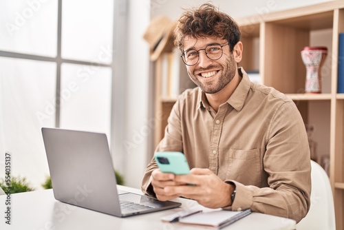 Young man business worker using smartphone and laptop working at office