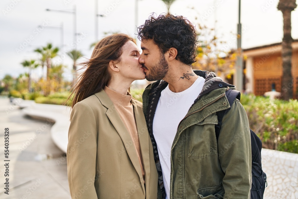 Fototapeta premium Man and woman kissing and hugging each other at street