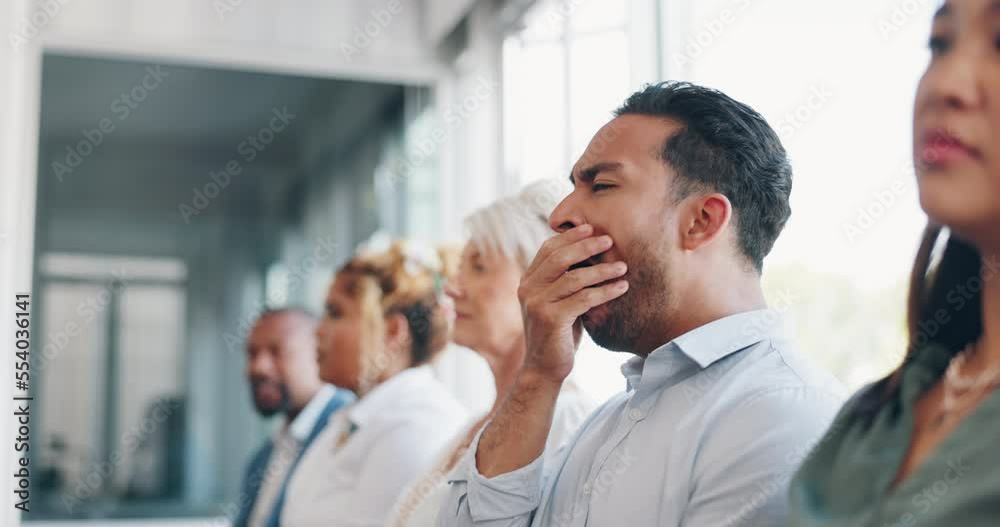 Tired, yawn and sleepless with a business man sitting in a meeting or presentation with his team for development. Yawning, exhausted and bored with a male employee suffering from insomnia at work
