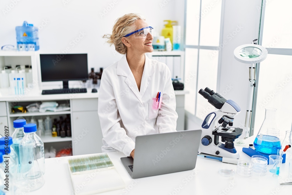 Middle age blonde woman wearing scientist uniform working at laboratory Middle age blonde woman wearing scientist uniform working at laboratory