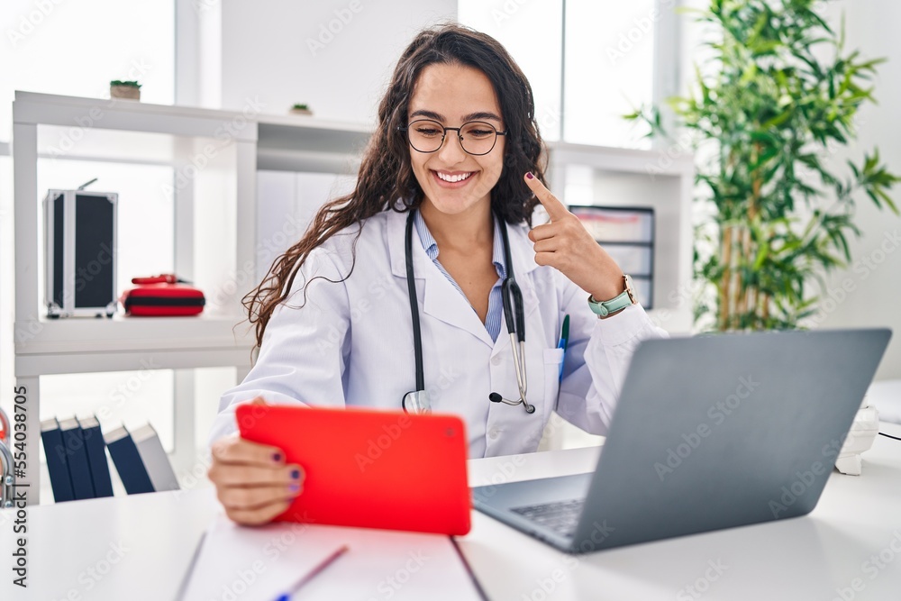 Young doctor woman working on online appointment smiling happy pointing with hand and finger Young doctor woman working on online appointment smiling happy pointing with hand and finger