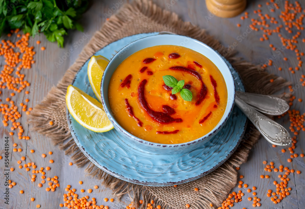 Mercimek Corbasi. Bowl of orange red lentil puree soup topped with paprika  oil paste, lemon wedges and fresh basil on woooden background. Selective  focus, horizontal. Photos | Adobe Stock