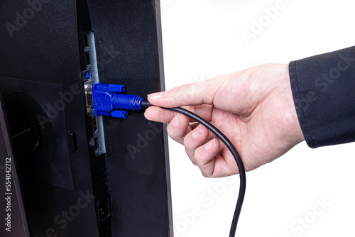 IT engineer Man hand inserts cable into monitor. Man hand connecting the DVI cable for monitor to computer PC. VGA DVI DisplayPort and power cable. close up in the hands of an . isolated