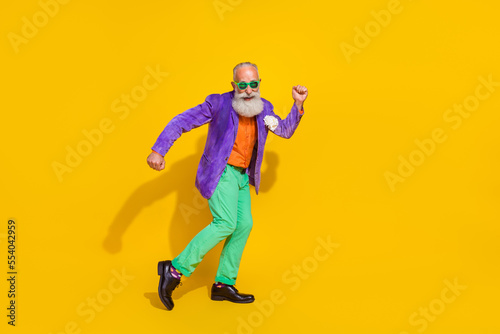 Full size photo of handsome grandpa hipster good mood energetic dance dressed stylish colorful clothes isolated on yellow color background