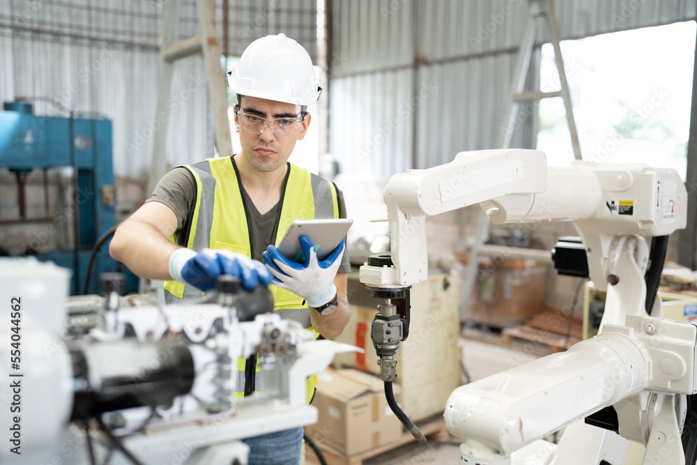 Caucasian technician engineer man use tablet computer control with checking machine arm robot at factory Caucasian technician engineer man use tablet computer control with checking machine arm robot at factory