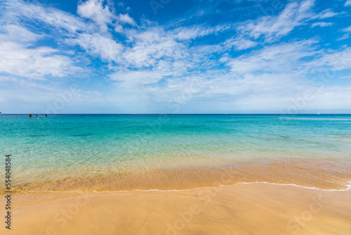 Turquoise ocean view of Jandia beach (Morro Jable). Landscape view of beach sea in summer day. At Jandia beach, Pájara, La Palma, Fuerteventura, Canary Islands. On 22 June 2022