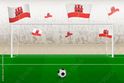 Gibraltar football team fans with flags of Gibraltar cheering on stadium, penalty kick concept in a soccer match.