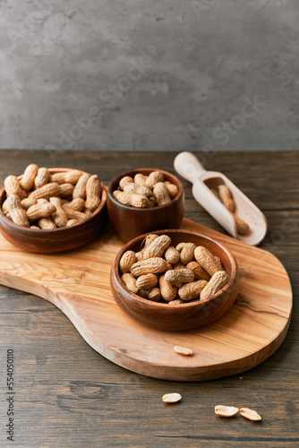Image of wooden spoons with peanuts on a wooden table