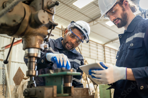 Team of engineers practicing maintenance Taking care and practicing maintenance of old machines in the factory so that they can be used continuously.