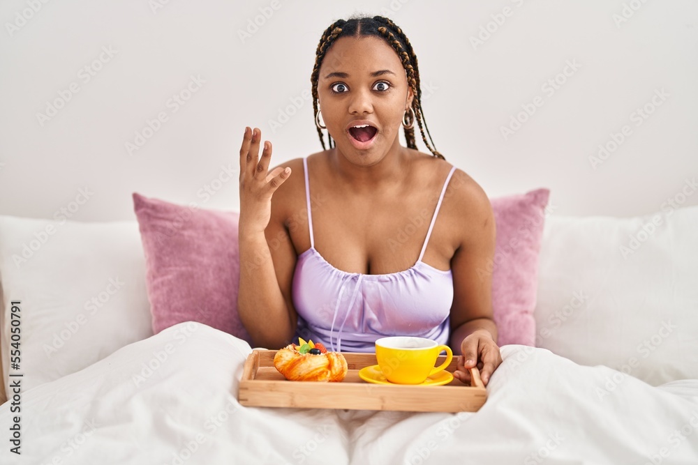 Φωτογραφία African american woman with braids holding tray with breakfast food in the bed c
