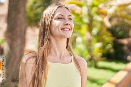 Young caucasian woman smiling confident looking to the side at park © Krakenimages.com