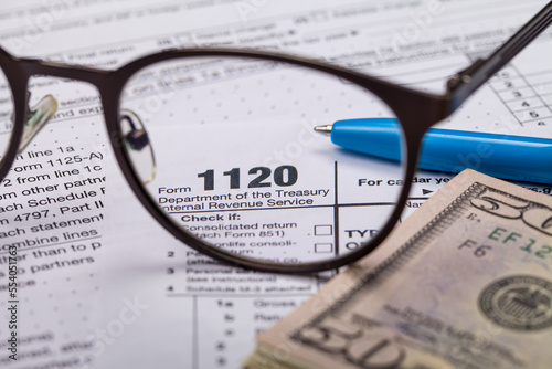 Income tax with instruction, money and glasses. Tax payment and filing concept