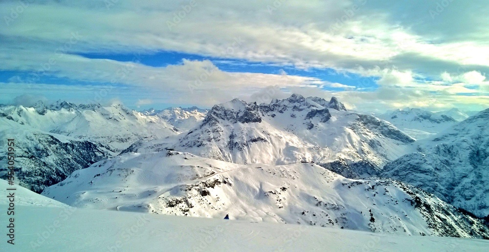 Bergpanorama im Winter mit Wolken und blauem Himmel beim Schifahren am Arlberg in Österreich