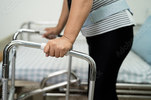 Asian lady patient pain her back, waist and orthopedic lumbar with walker.