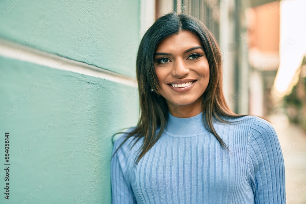 Beautiful hispanic woman smiling confient leaning on the wall Beautiful hispanic woman smiling confient leaning on the wall