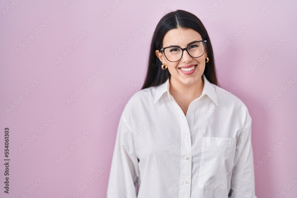 Young brunette woman standing over pink background with a happy and cool smile on face. lucky person. Young brunette woman standing over pink background with a happy and cool smile on face. lucky person.