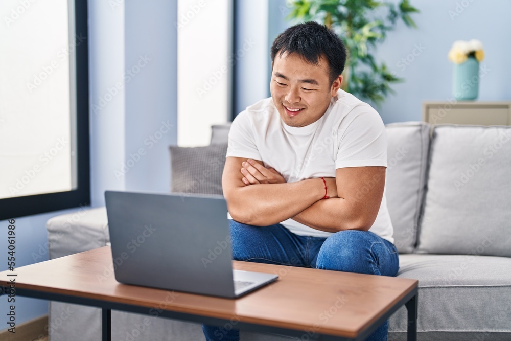 Young chinese man watching movie sitting on sofa at home Young chinese man watching movie sitting on sofa at home